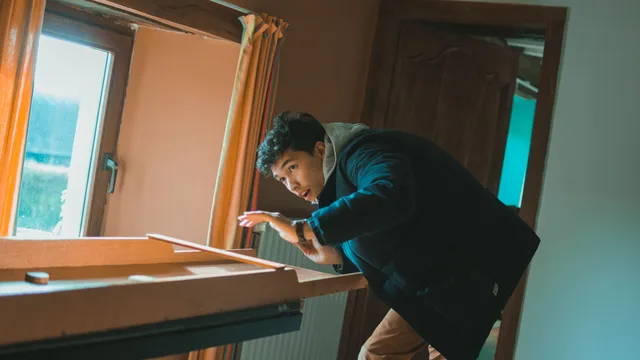 A young man intensely playing a tabletop game in a cozy indoor setting. Game master pay bands for an escape room business in 2027